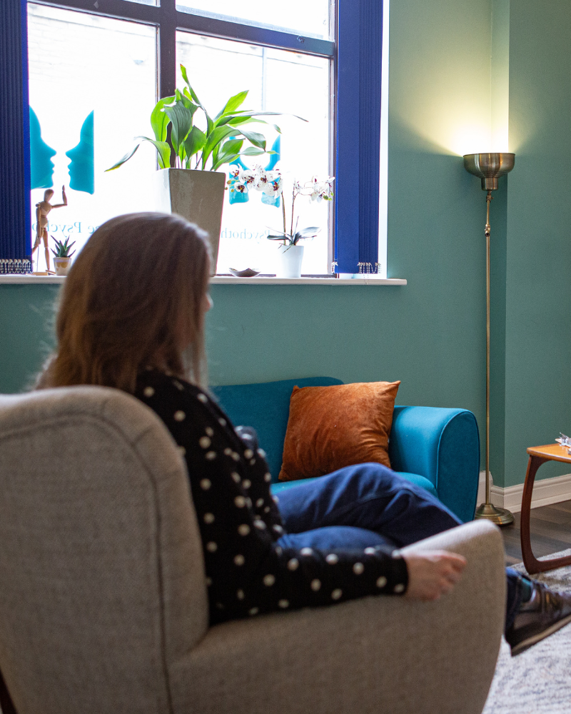 woman sitting on chair in a supportive trauma therapy session